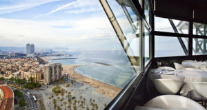 the beautiful barcelona skyline shot through the window of an exlcusive rooftop restaurant